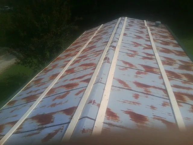 Rusted metal roof panels with new wood purlins before replacement — Storm Damage Roof Repair in Shaw Afb by Roofing Brothers