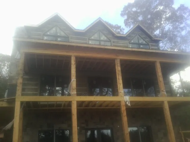 Dormers and porch framing on a large log home under construction — Roof Coating work by our crew in Shaw Afb
