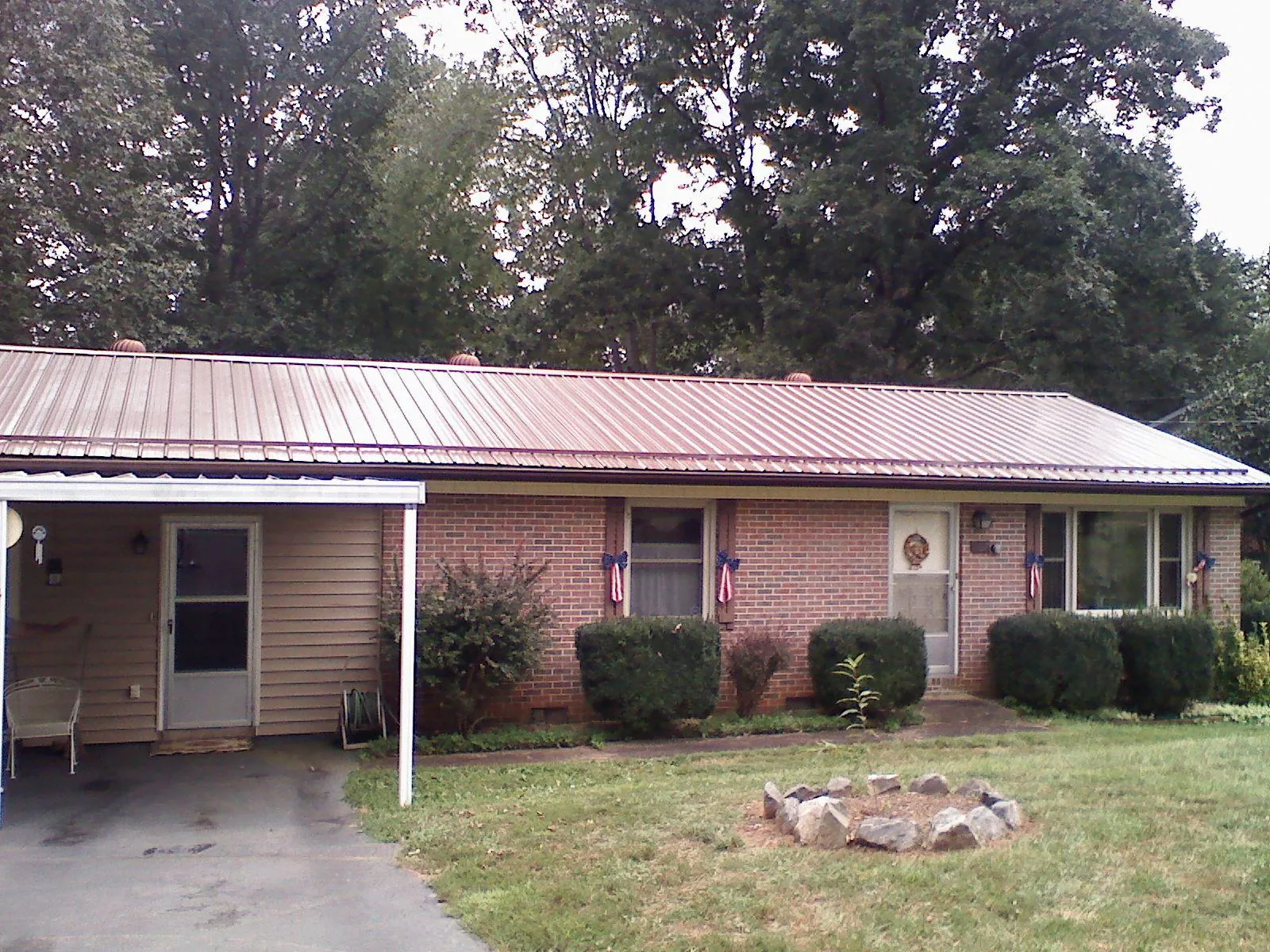 Bronze metal roof and carport on a brick ranch home — Roof Repair work by our crew in Shaw Afb