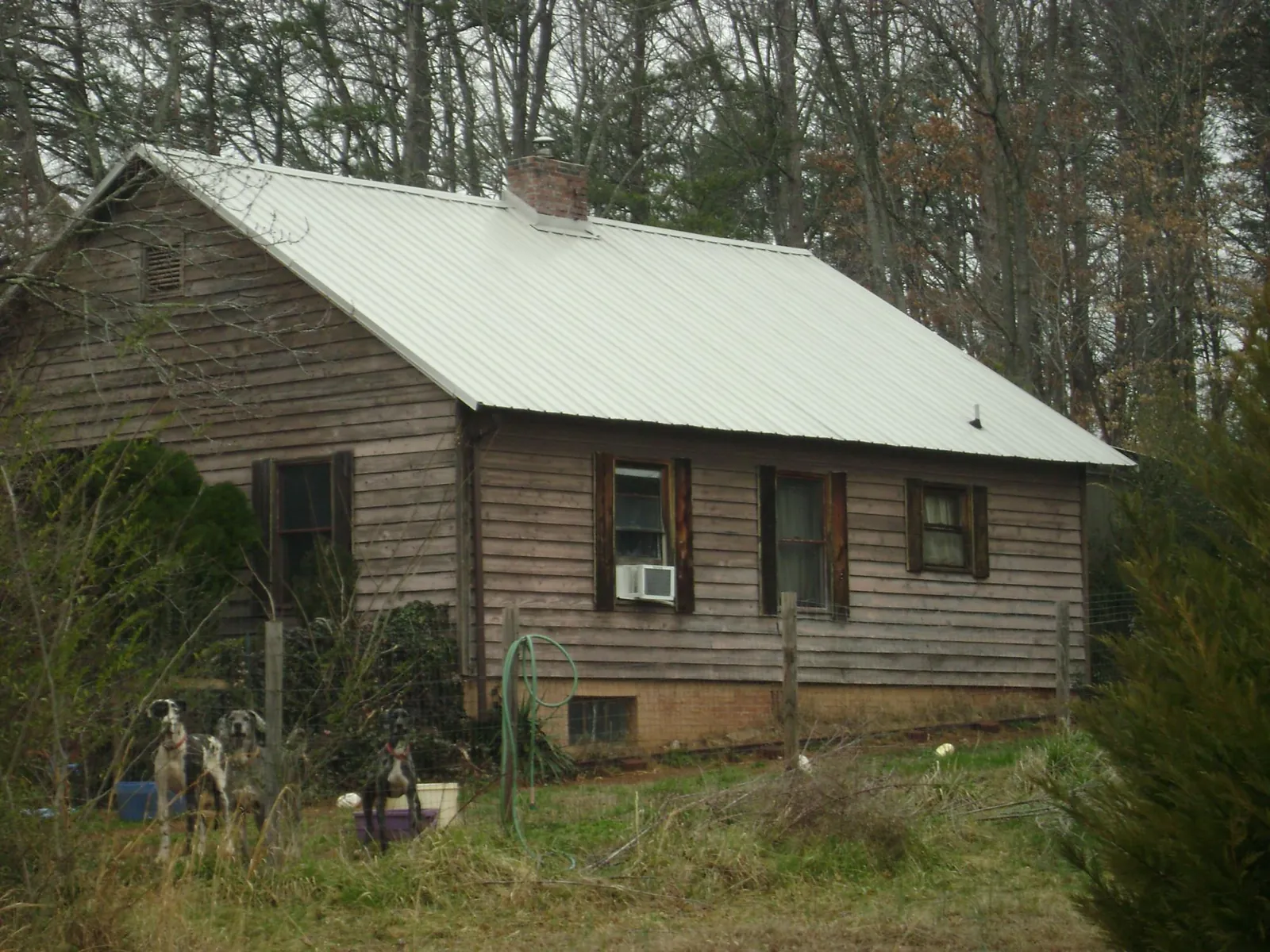White metal roof on an old wood sided farmhouse, from a Asphalt Shingle Roof Repair job in Shaw Afb